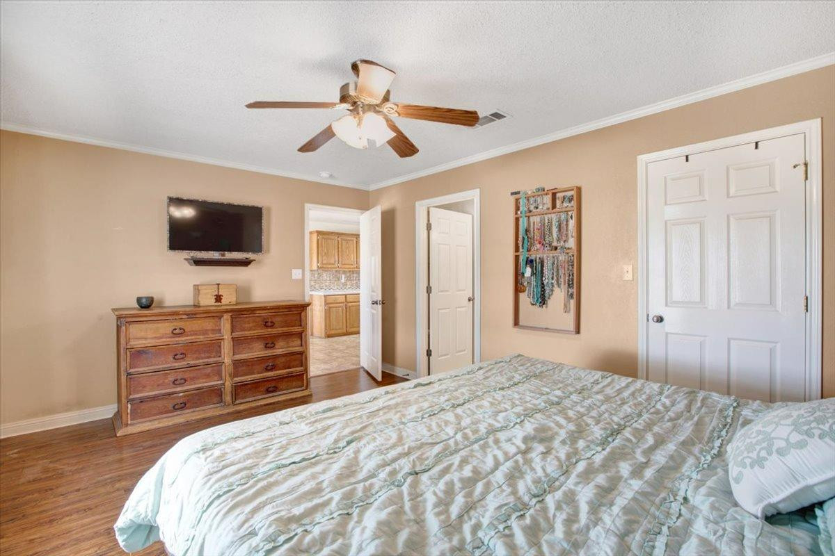 1703 Owl Road Lubbock, TX 79407 - Photo 14 of 33 a bedroom with a bed and wooden floor