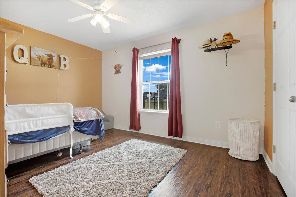 1703 Owl Road Lubbock, TX 79407 - Photo 18 of 33 a bedroom with a bed and wooden floor