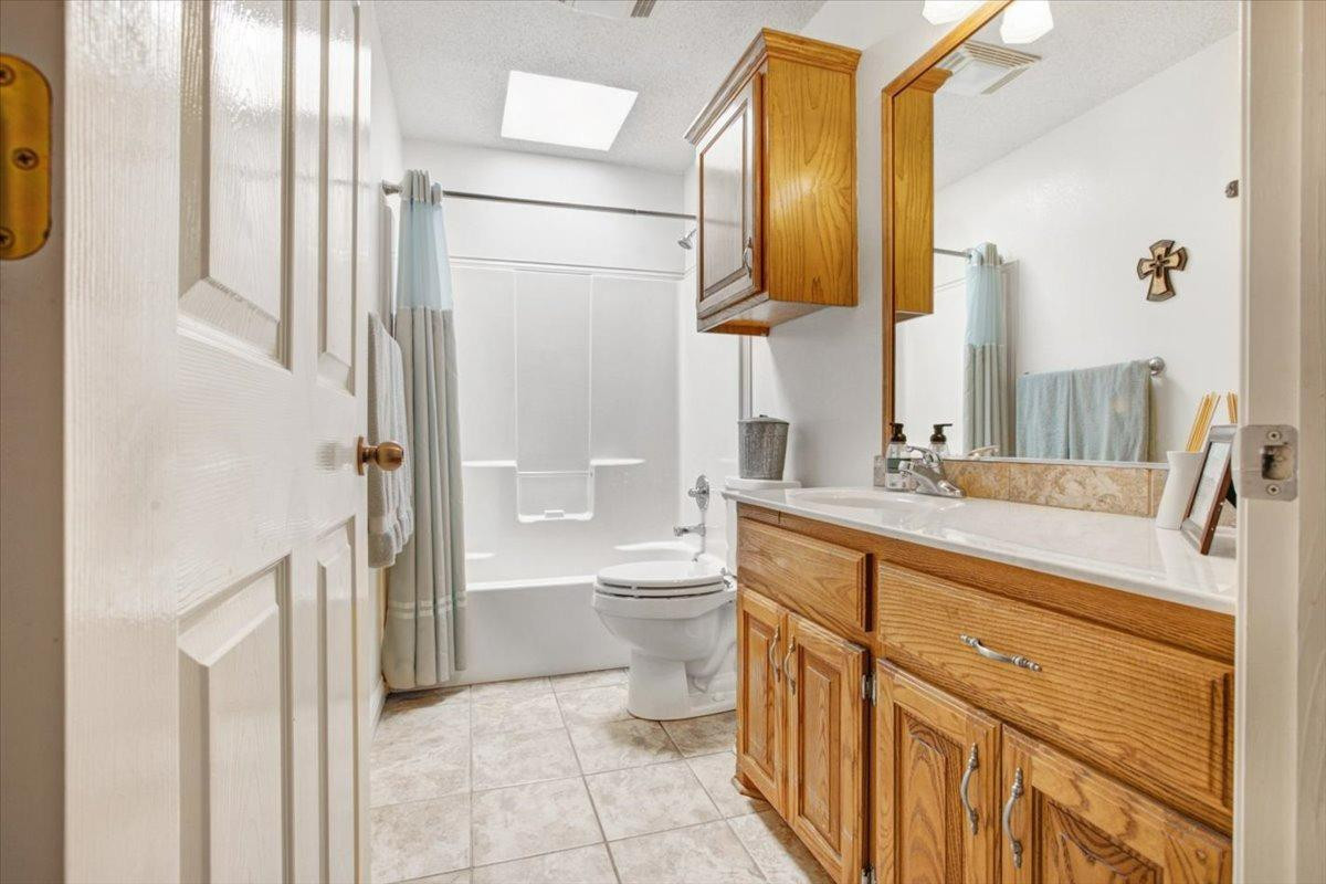 1703 Owl Road Lubbock, TX 79407 - Photo 19 of 33 a bathroom with a granite countertop sink toilet and shower