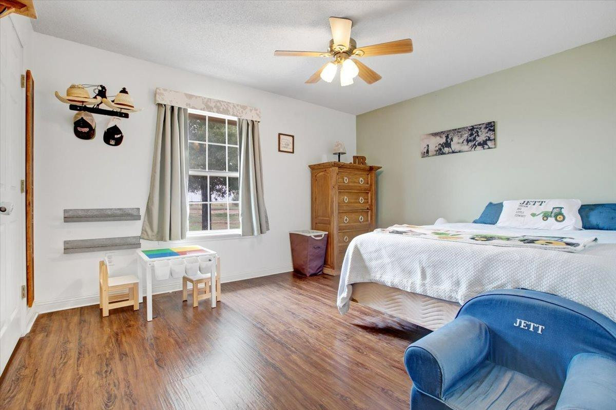 1703 Owl Road Lubbock, TX 79407 - Photo 20 of 33 a bedroom with a bed and a chair in it