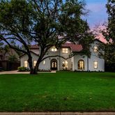 a big white house with a big yard and large trees