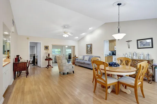 a dining room with furniture a chandelier and wooden floor