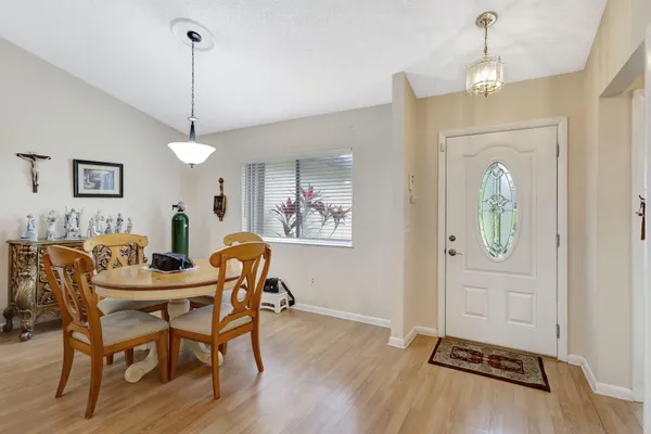 a dining room with chandelier and wooden floor