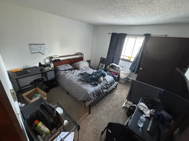 a bedroom with furniture and a air conditioner vent