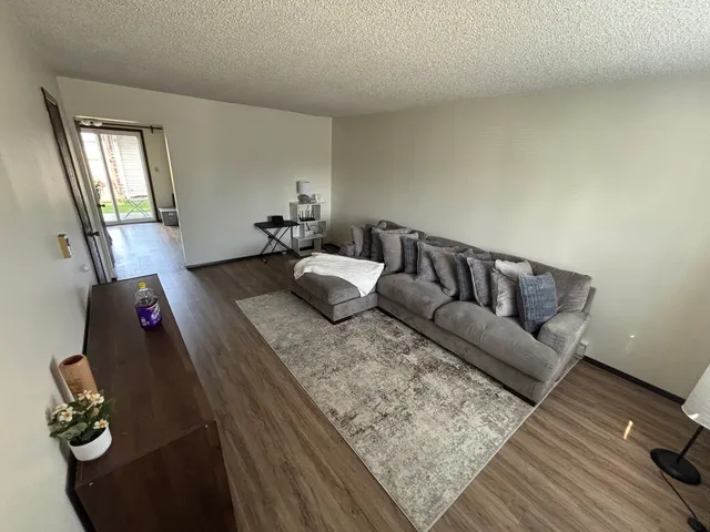a living room with furniture and wooden floor