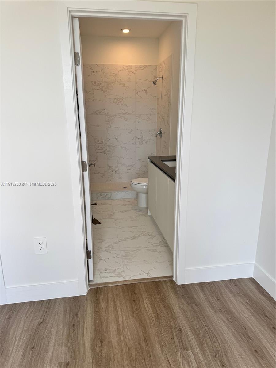 18932 Southwest 344th Terrace, Unit 18932 Homestead, FL 33034 - Photo 15 of 19 an empty room with wooden floor and toilet