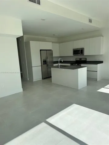 a kitchen with stainless steel appliances a refrigerator and a stove top oven
