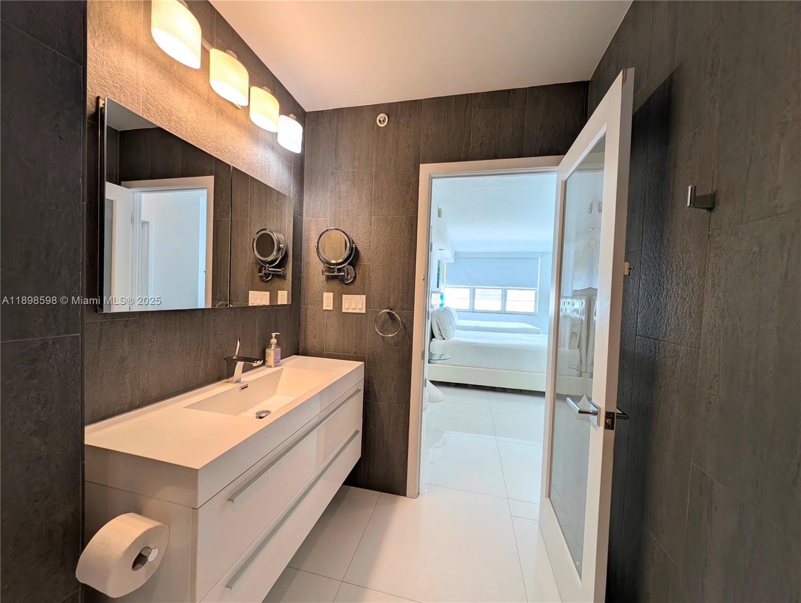 100 Lincoln Road, Unit 1008 Miami Beach, FL 33139 - Photo 8 of 13 a bathroom with a sink and mirror