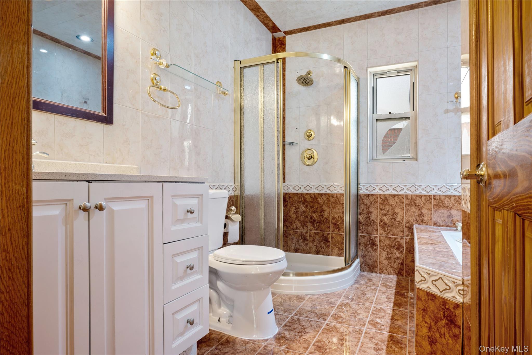 73-33 188th Street Queens, NY 11366 - Photo 12 of 31 Bathroom with vanity, tile walls, tile patterned flooring, and a stall shower