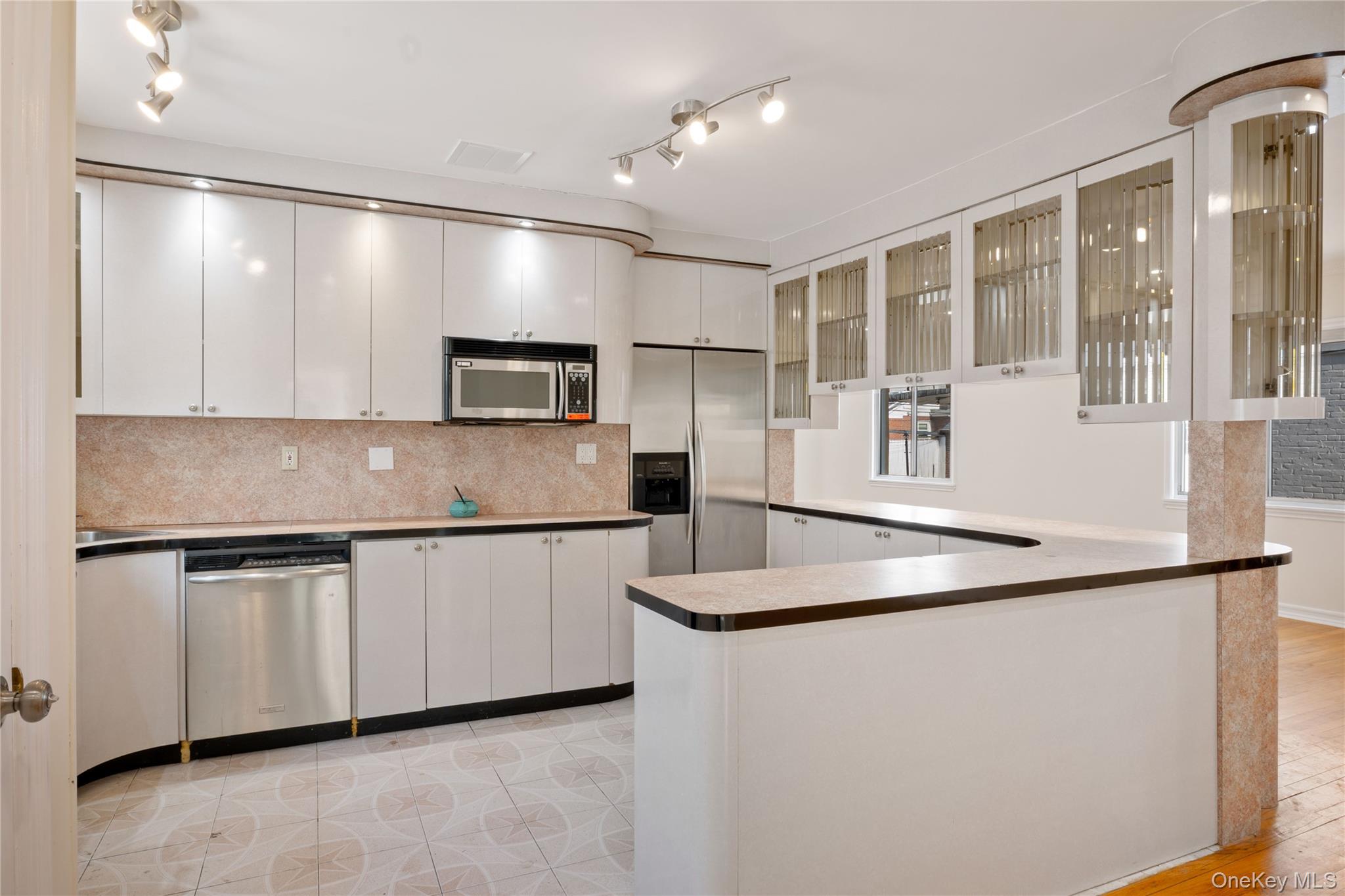 73-33 188th Street Queens, NY 11366 - Photo 8 of 31 Kitchen featuring white cabinets, backsplash, visible vents, glass insert cabinets, and appliances with stainless steel finishes