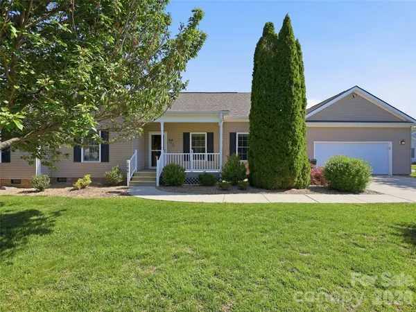 a front view of a house with a yard and trees