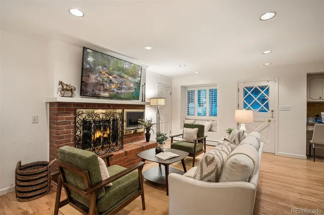 a living room with furniture a fireplace and a floor to ceiling window