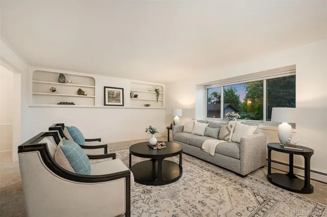 a living room with furniture a rug and a large window