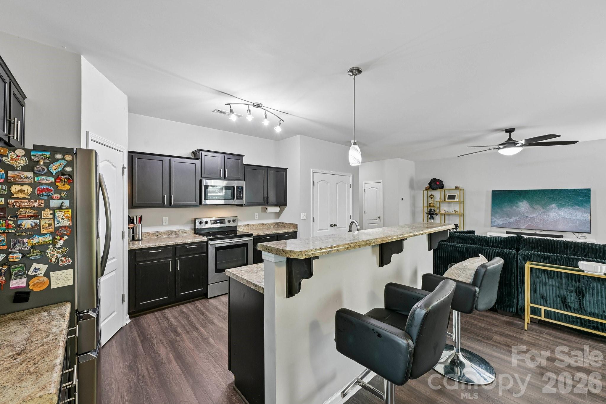 2206 Turtle Point Road Charlotte, NC 28262 - Photo 9 of 28 a kitchen with stainless steel appliances kitchen island granite countertop a stove top oven a sink dishwasher a dining table and chairs with wooden floor
