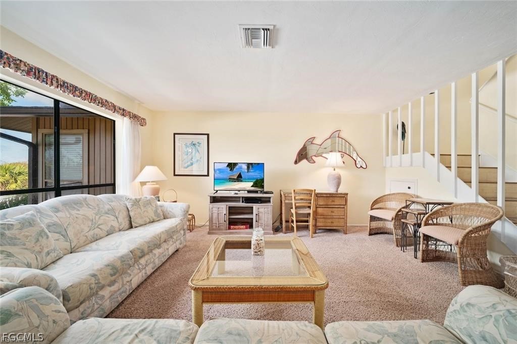5117 Sea Bell Road, Unit F206 Sanibel, FL 33957 - Photo 17 of 47 a living room with furniture a large window and a flat screen tv