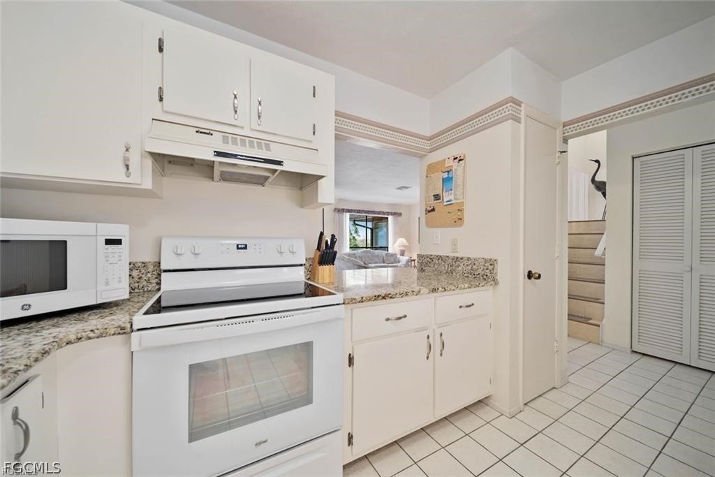 5117 Sea Bell Road, Unit F206 Sanibel, FL 33957 - Photo 31 of 47 a kitchen with white cabinets and white appliances