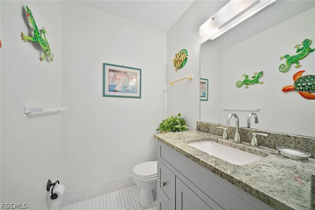 5117 Sea Bell Road, Unit F206 Sanibel, FL 33957 - Photo 33 of 47 a bathroom with a granite countertop sink a toilet and mirror