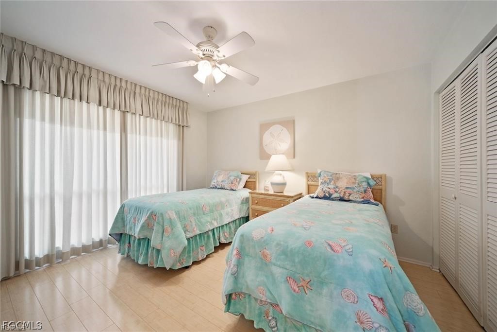 5117 Sea Bell Road, Unit F206 Sanibel, FL 33957 - Photo 35 of 47 a bedroom with two beds and a chandelier