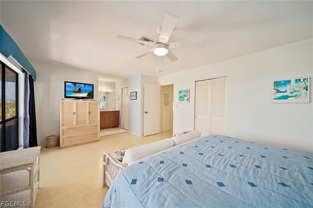 5117 Sea Bell Road, Unit F206 Sanibel, FL 33957 - Photo 41 of 47 a bedroom with a large bed and a chandelier