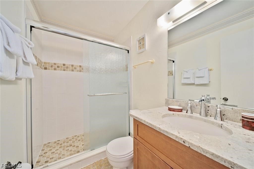 5117 Sea Bell Road, Unit F206 Sanibel, FL 33957 - Photo 43 of 47 a bathroom with a granite countertop sink toilet and shower