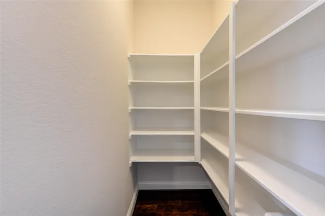 a walk in closet with white walls