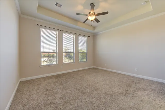 en empty room with windows and ceiling fan