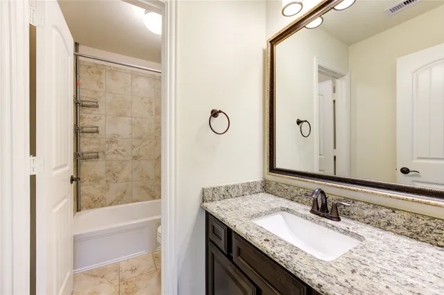 a bathroom with a granite countertop sink and a mirror