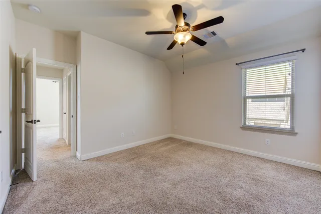 an empty room with a window and a fan