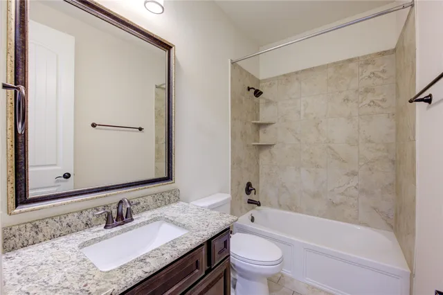 a bathroom with a granite countertop sink toilet mirror and shower