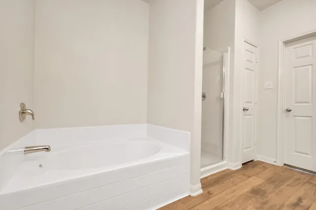 an empty room with windows and chandelier fan