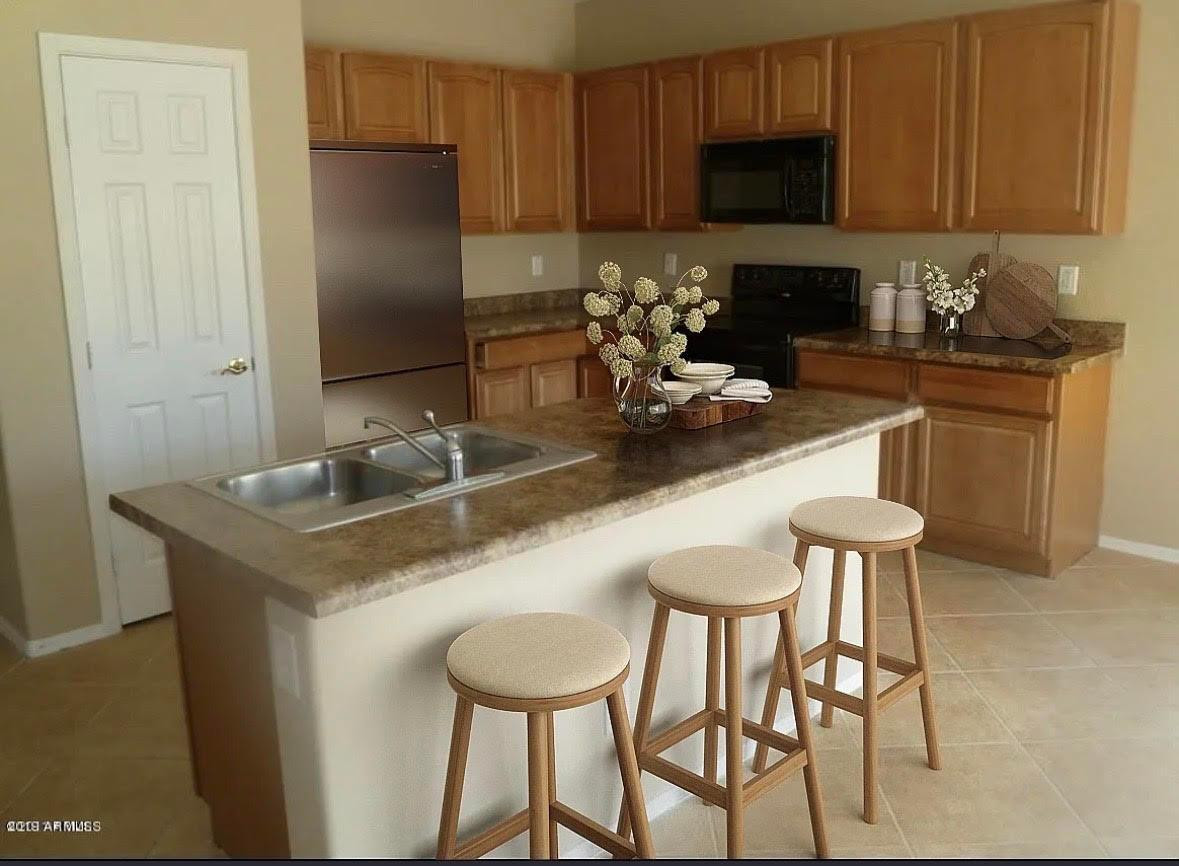 430 South 166th Avenue Goodyear, AZ 85338 - Photo 2 of 17 a kitchen with stainless steel appliances granite countertop a sink a stove a refrigerator with a dining table and chairs