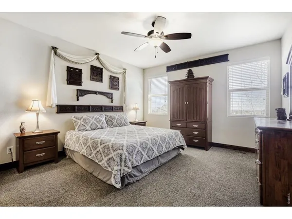 a bedroom with a bed and a ceiling fan