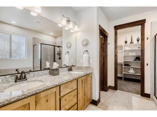 a bathroom with a granite countertop sink mirror and a shower