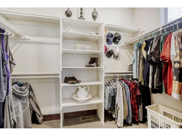 a view of walk in closet with clothes and shoes