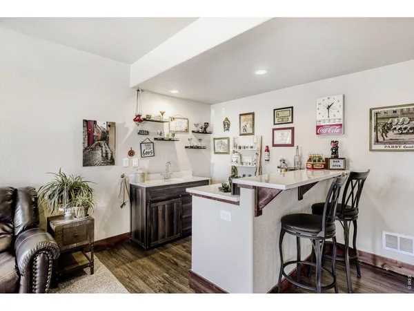 a kitchen with stainless steel appliances kitchen island granite countertop a dining table chairs and a refrigerator