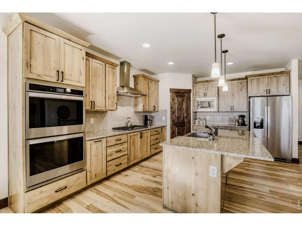 a kitchen with stainless steel appliances kitchen island granite countertop a stove a sink and a microwave