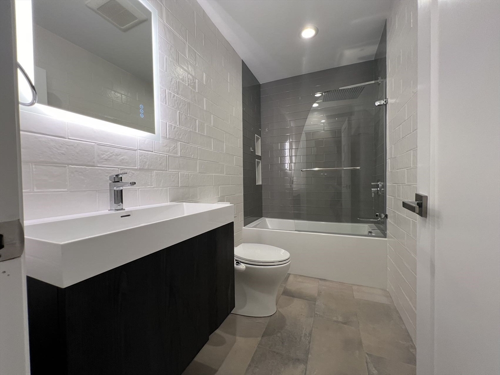 23 Winslow Road, Unit 1 Brookline, MA 02446 - Photo 10 of 27 a bathroom with a sink a toilet and shower