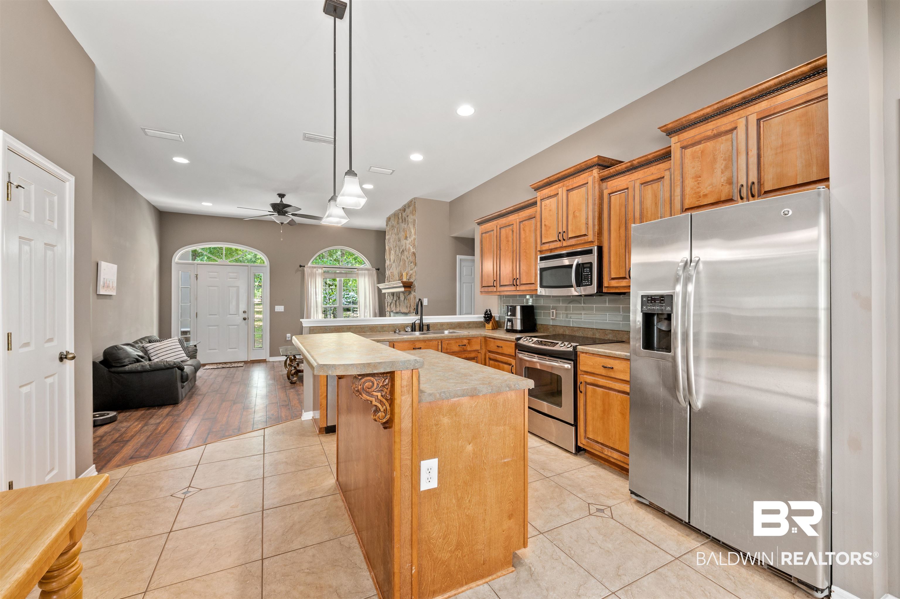 15240 Styx River Road Stapleton, AL 36578 - Photo 14 of 18 Kitchen featuring ceiling fan, kitchen peninsula, decorative light fixtures, stainless steel appliances, and light wood-type flooring