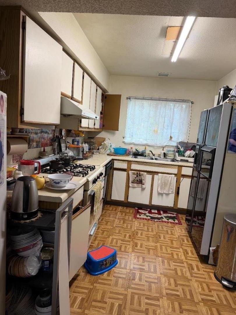 5957 Mack Road Sacramento, CA 95823 - Photo 4 of 9 a kitchen with a stove a sink and a microwave