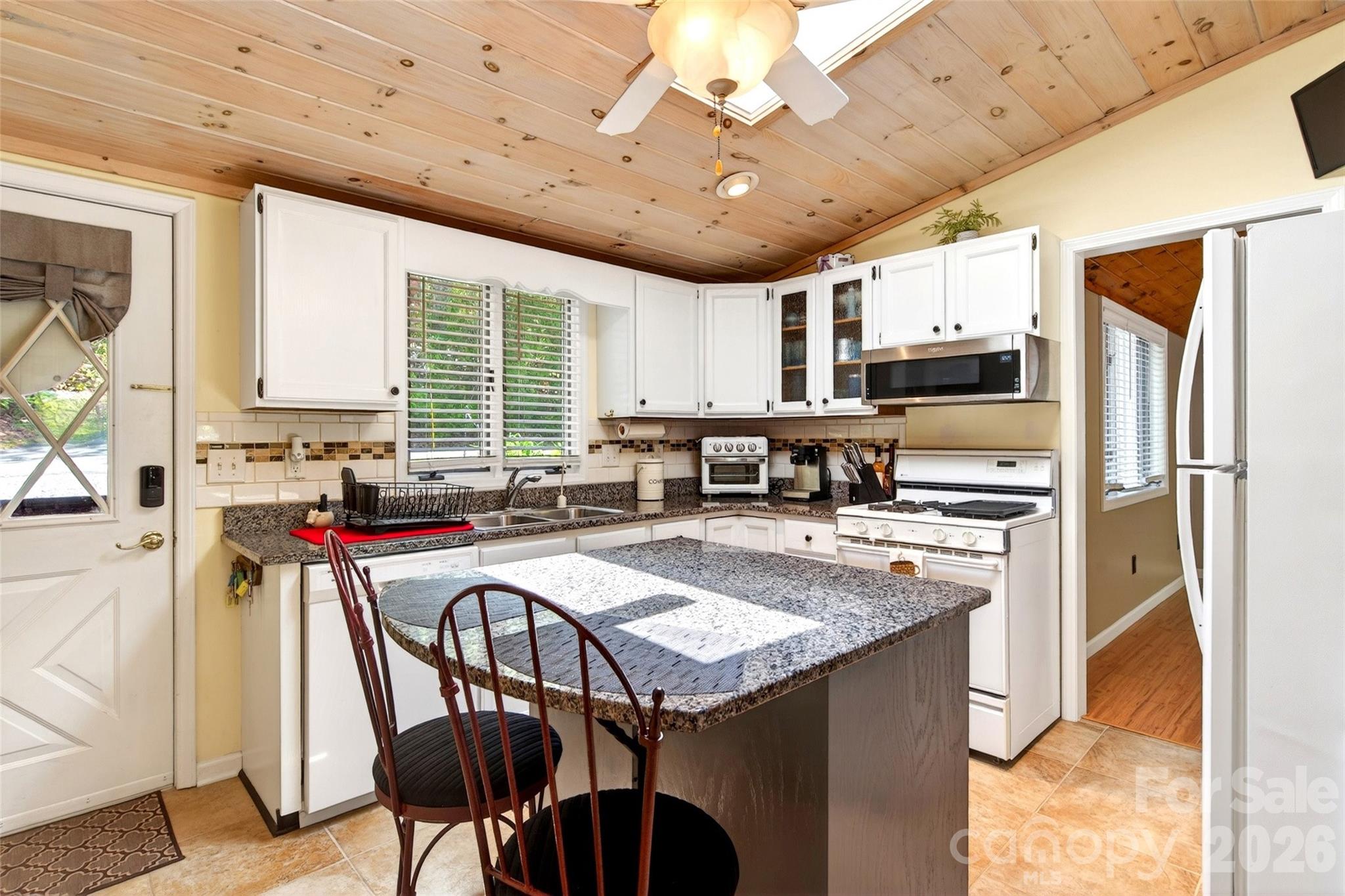 334 Harbor Lake Road Newland, NC 28657 - Photo 5 of 48 a kitchen with stainless steel appliances granite countertop a table chairs sink refrigerator and microwave