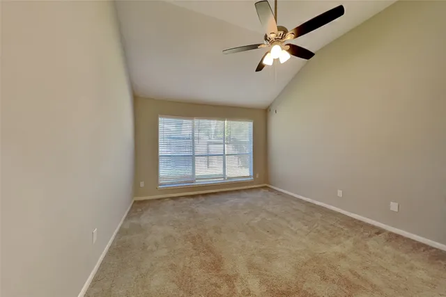 an empty room with a window and a fan