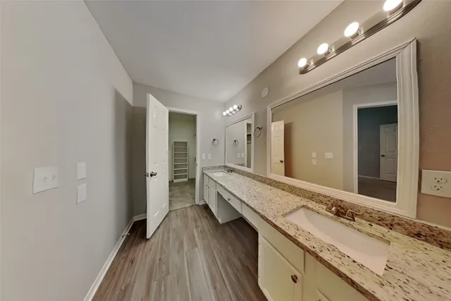 a bathroom with a granite countertop double vanity sink and mirror