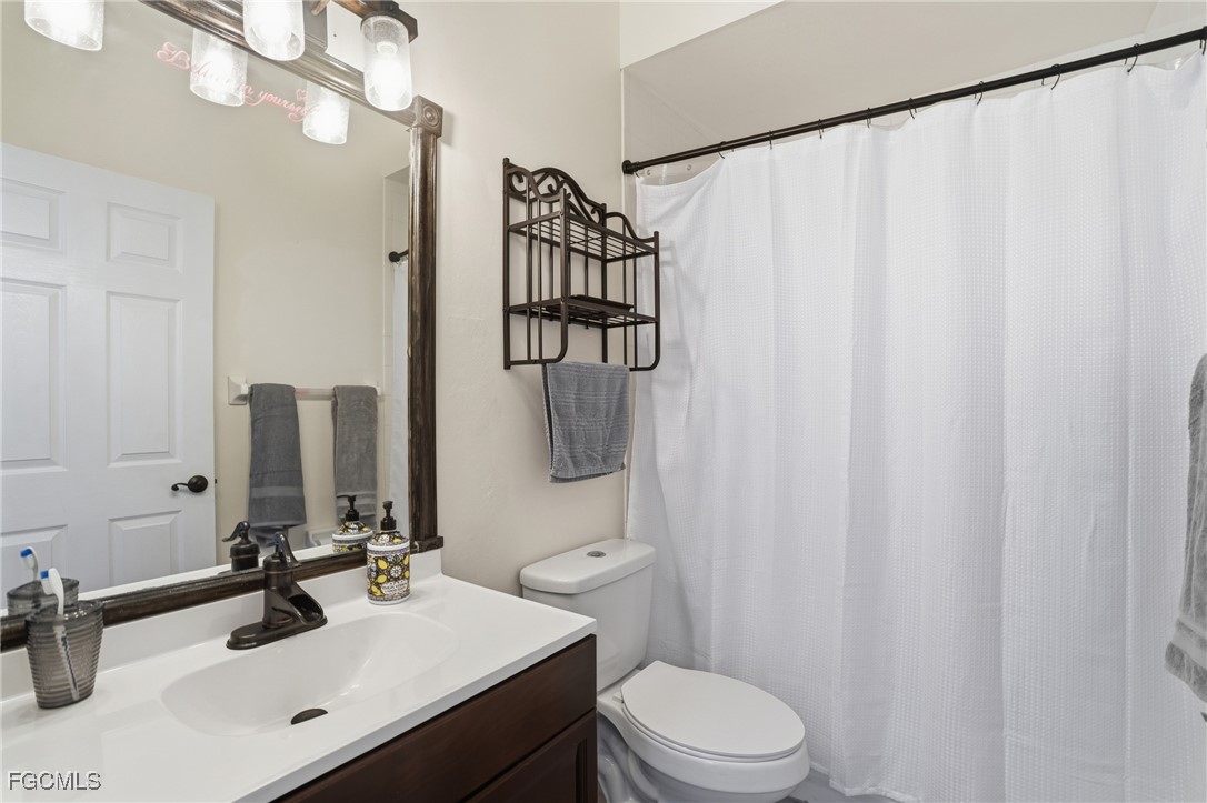 10733 Rio Mar Circle Estero, FL 33928 - Photo 14 of 40 a bathroom with a sink vanity mirror and toilet