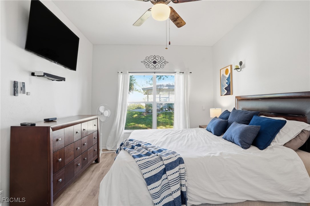 10733 Rio Mar Circle Estero, FL 33928 - Photo 16 of 40 a bedroom with a large bed and a flat tv screen on dresser