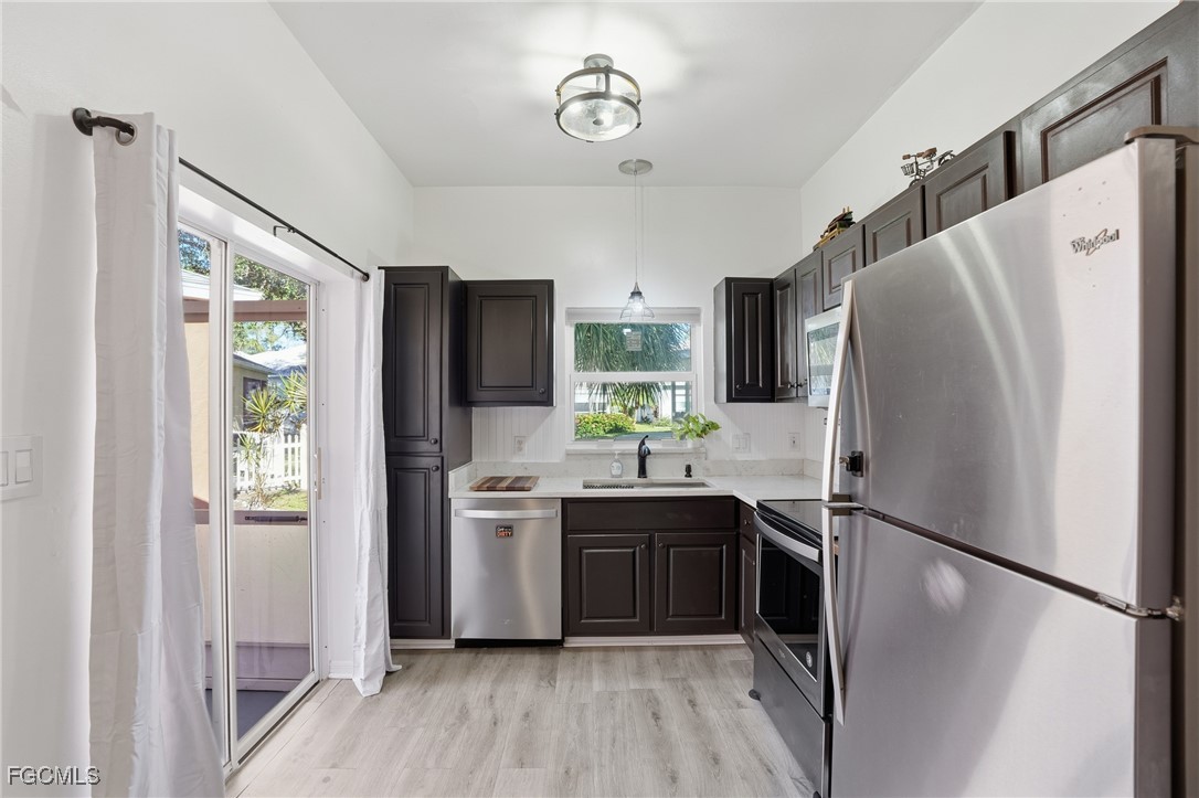 10733 Rio Mar Circle Estero, FL 33928 - Photo 5 of 40 a kitchen with stainless steel appliances a refrigerator sink and cabinets