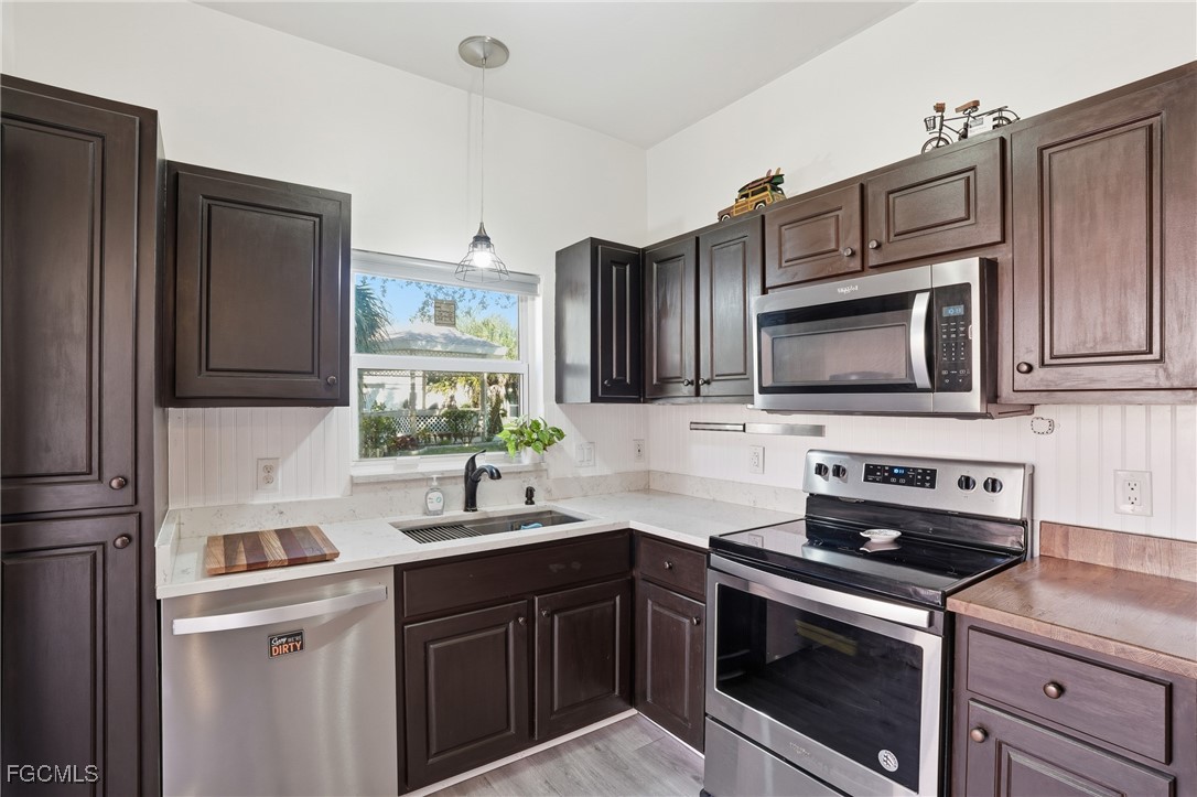 10733 Rio Mar Circle Estero, FL 33928 - Photo 7 of 40 a kitchen with stainless steel appliances granite countertop a sink stove and microwave