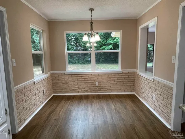 a view of a room with wooden floor and a window