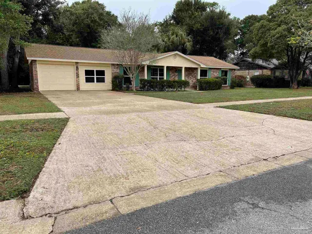 a front view of a house with a yard and trees