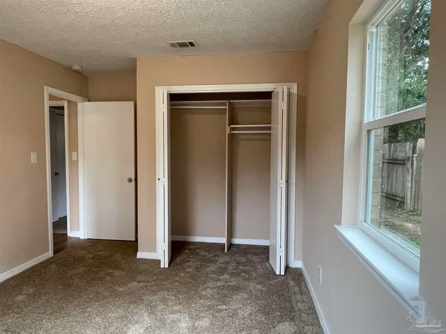 an empty room with windows and closet