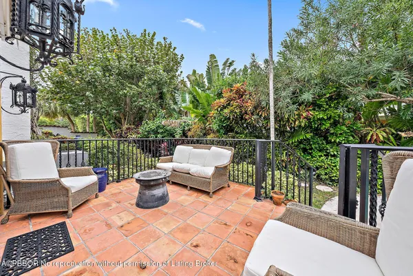 a view of a balcony with two chairs and a potted plant